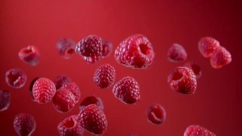 Ripe raspberry fly on a red background Video stock 105574747