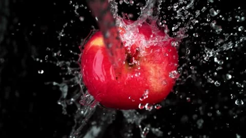 Ripe red apple is washed by clean water stream on black background closeup .. Stock Footage 327578762
