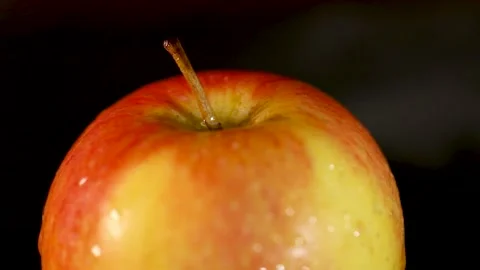 Ripe red apple with water drops swirl on black background. Stock Footage 220398877
