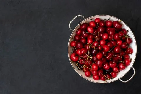 Ripe red cherries in a white colander Stock Photos