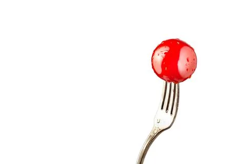 Ripe red cherry tomato on a fork on a white background, isolate, place under the Stock Photos