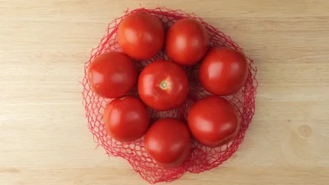 Ripe red cherry tomatoes rotating on a wooden table Stock Footage 347685696