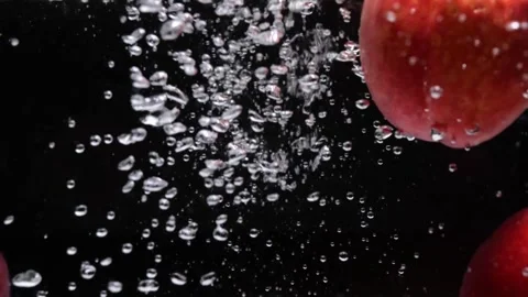 Ripe red nectarines fall into water on black background Stock Footage 156470230