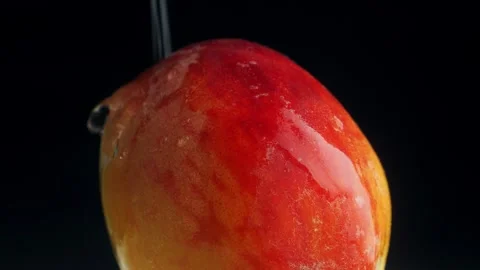 Ripe red peach is poured with a stream of water on a black background. Clos.. Stock Footage 283390661