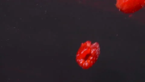 Ripe red raspberries are falling into juice with beautiful splashes Stock Footage 127643821