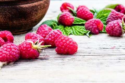 Ripe red raspberry lies on the background of old boards. Selective focus. Stock Photos