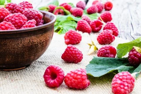 Ripe red raspberry lies on the background of old boards. Selective focus. Stock Photos