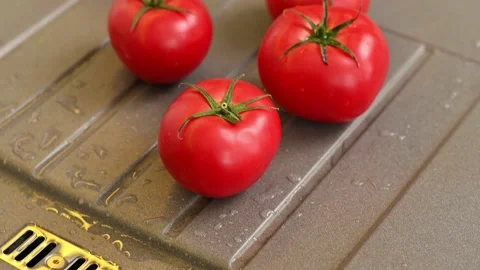 Ripe red tomatoes with splashes from water lie on the sink in kitchen at home Stock Footage 199082256