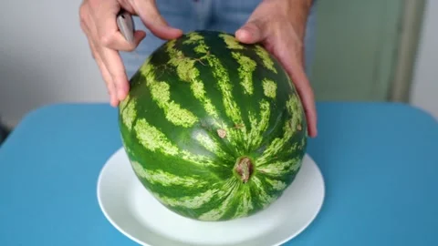 Ripe red watermelon cut in half with a knife Stockbeeldmateriaal 161731798