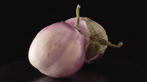 Ripe round eggplants on a black background close up Stock Footage 137442633