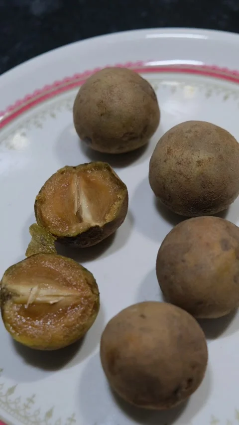Ripe Sapota fruit cut open showing brown juicy pulp and seeds Видео 331621175