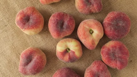 Ripe Saturn peaches rotating on burlap Stock Footage 342437604