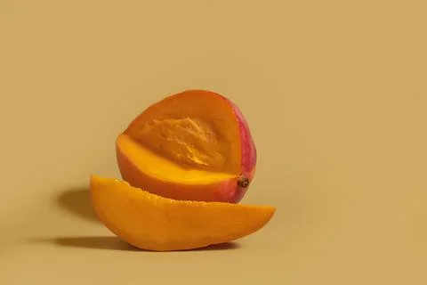 Ripe sliced mango and a slice on a colored background Stock Photos