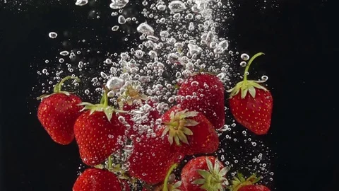 Ripe Strawberries Falling through the Water. 库存影片 78419650
