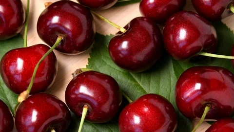 Ripe sweet cherry rotating top view on wooden background Stock Footage 111596376
