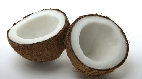 Ripe tropical coconut split in two halves rotating on white background. Looping Stock Footage 70502037