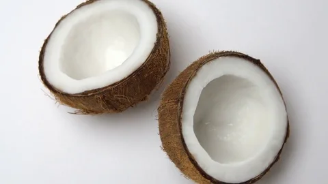 Ripe tropical coconut split in two halves rotating on a white background Stock Footage 71059202