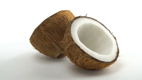 Ripe tropical coconut split in two halves rotating on a white background Stock Footage 71178765