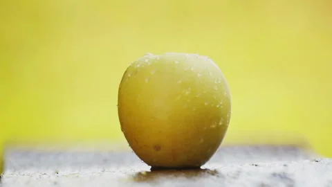 A ripe yellow apple under a stream of water. Stock Footage 114442308