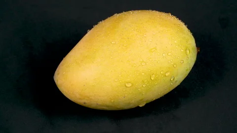 Ripe Yellow Mango with Water Drops Rotating on Black Background Stock Footage 335259634