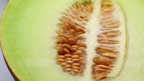 A ripe yellow melon, cut in half, rotation in circle. half a melon with bones Stock Footage 252796831