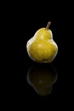 Ripe yellow pear fruit, with reflection, isolated on black Stock Photos