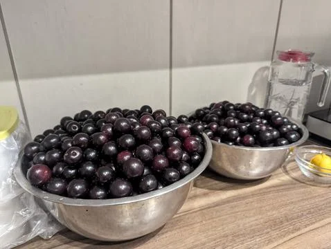 Ripened Cherries And Kitchen Tools. Dark Cherries In Stainless Bowls With J.. Stock Photos