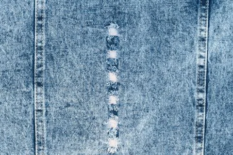 Ripped blue denim fabric texture with seams and distressed details Fotos Stock