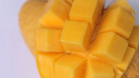 Ripped mango slice cubes cut rotating on a white background 스톡 동영상 274250758