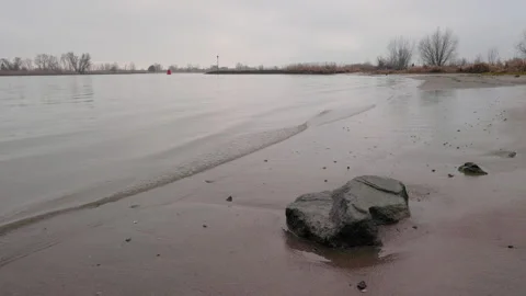 Rippeling waves at the river Lek with rock on foreground in The Netherlands Stock Footage 168947778