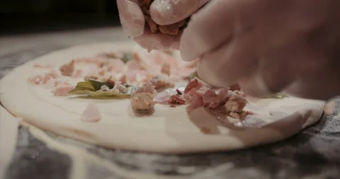 Ripping up and placing ham on a pizza Stock Footage 105300352