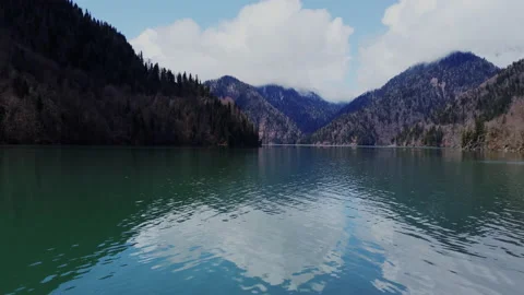 Ripple Water Surface with Mountain Reflection in a Mountain Forest Lake with Stock Footage 153375007