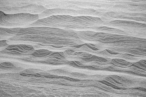 Rippled lines forming pattern on icy snow landscape Stock Photos