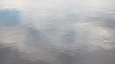 Ripples and reflections of the sky on the river water. Waves on the water Stock Footage 153380277