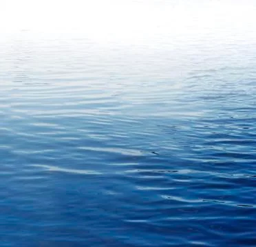 Ripples on blue water surface Stock Photos