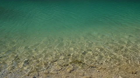 Ripples of clear gradient water in the river, rocky bottom under the water. Sun Stock Footage