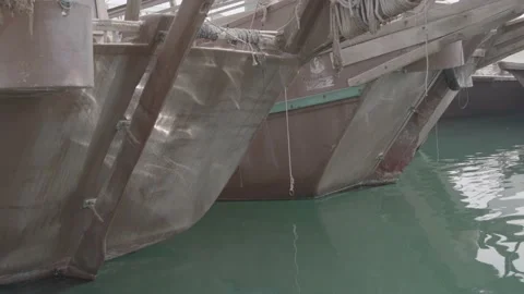 Ripples of the waves reflect the sun on the hulls of fishing boats in slowmo Stock Footage 135452862