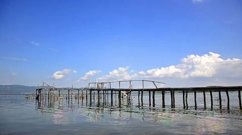 Rippling lake surface and silhouettes of wooden posts making pattern of verti Stock Footage 42396444