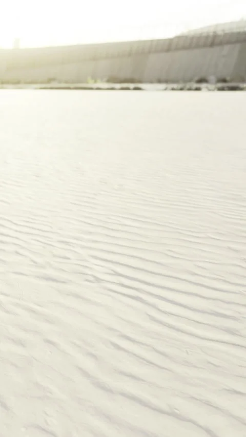 Rippling patterns of sand under the golden sun at a serene beach Stock Footage 334207703