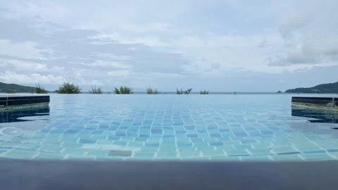 Rippling water on pool surface as tropical plants sway in breeze Stock Footage 302154019