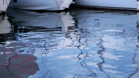 Rippling water surface reflecting moored sailboats Stock Footage 340920800