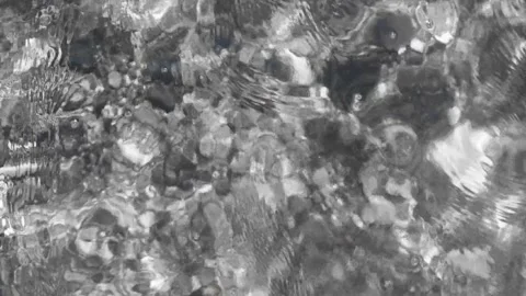 Rippling Water Surface Reflecting Sunlight With Natural Stones Under Clear Water Stock Footage 306592912