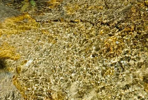 Rippling waves of a mountain brook generates light interferences in cristall  Stock Photos