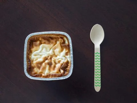 Rise pudding on dark brown table with turquoise spoon Stock Photos