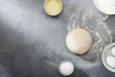 Risen or proved yeast dough for bread or pizza on a floured slate surface. Stock Photos