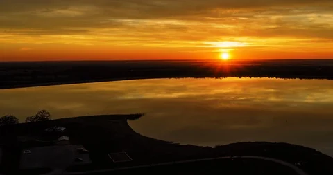 Rising aerial of cloudy sunset over calm lake Stock Footage 122648070
