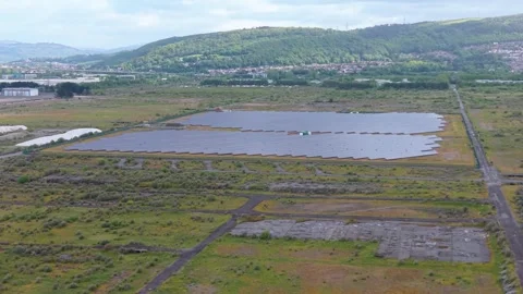 Rising Aerial of Modern Solar Panel Array with Houses and Hill in Background Stock Footage 335286930