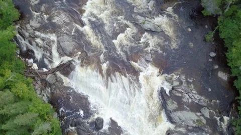 Rising aerial shot looking down at raging waterfall in a river Video stock 79605567