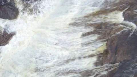 Rising aerial shot looking down at raging waterfall in a river Stock Footage 79606179