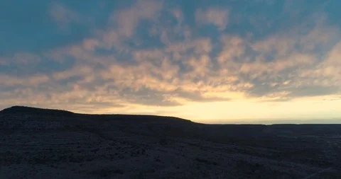 Rising up to beautiful sunset, clouds lit to orange at dusk drone aerial 4K Stock Footage 111316444